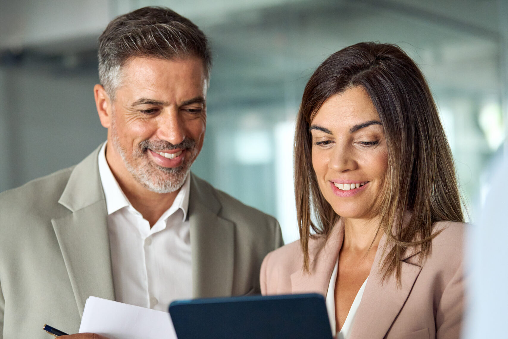 busy business executives using tablet having discussion standing in office.