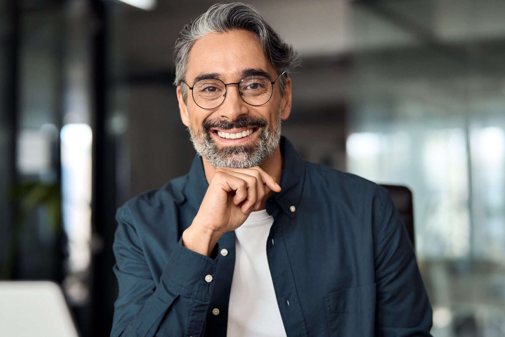happy middle aged business man working on laptop in office, vertical portrait.